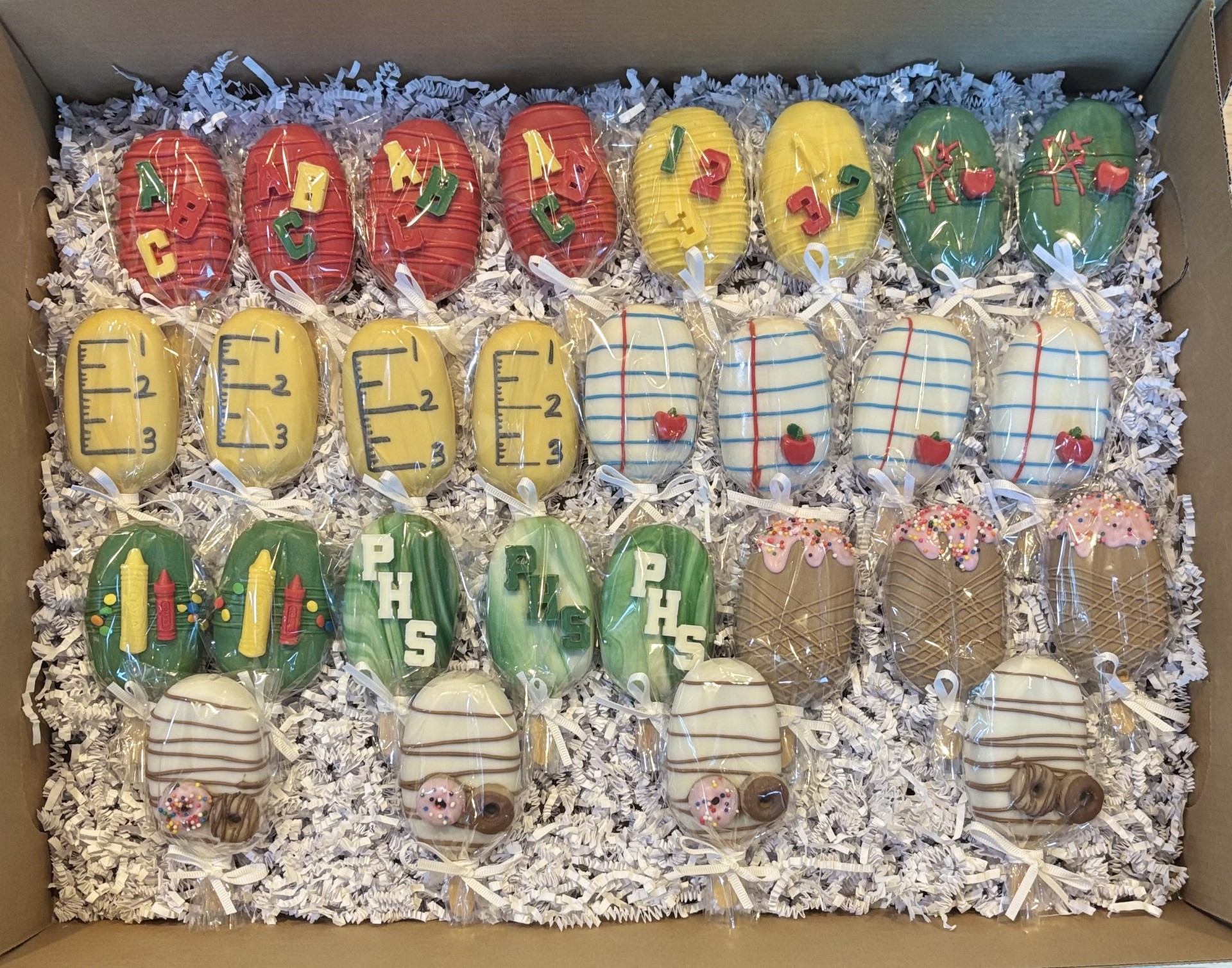 Back to school themed cakesicles with letters, rulers, and school designs